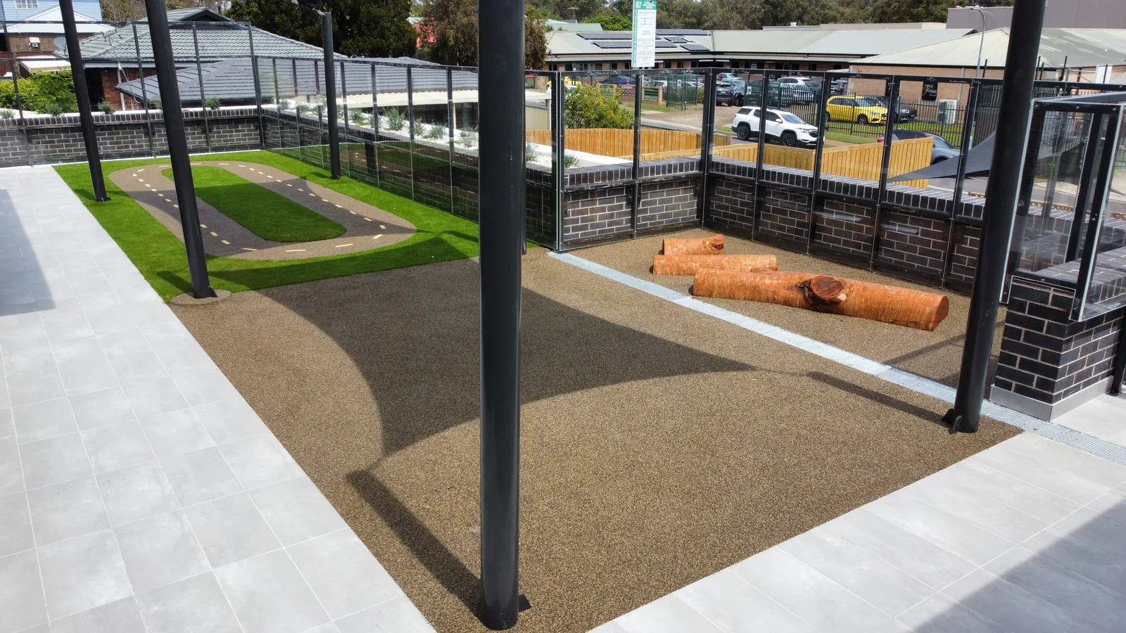 Upper-level childcare play deck with rubber softfall race track and synthetic lawn — JL Turf Group