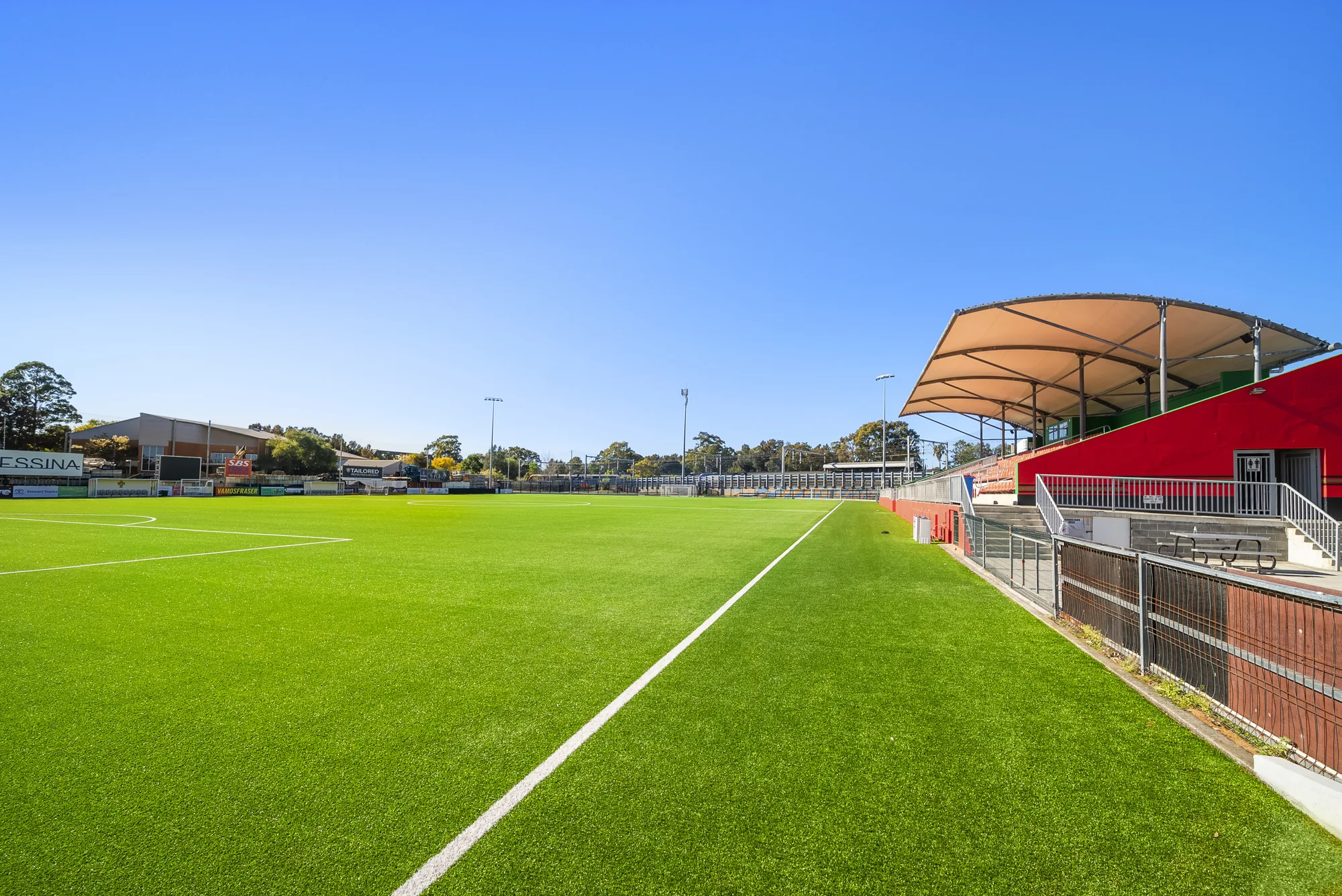 Completed FIFA-grade synthetic football pitch at Fraser Park, Marrickville, with the grandstand alongside — built by JL Turf Group