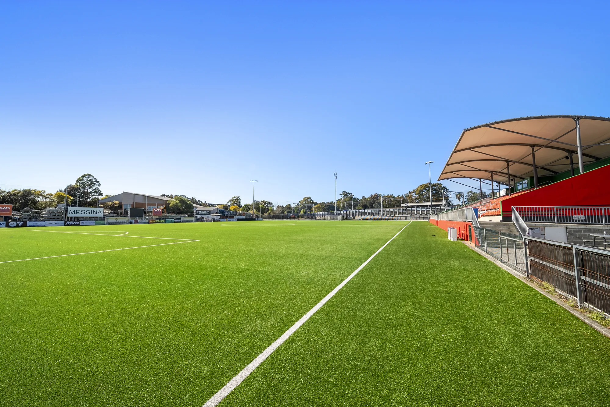 Sideline view of the synthetic turf and grandstand at Fraser Park, Marrickville, installed by JL Turf Group
