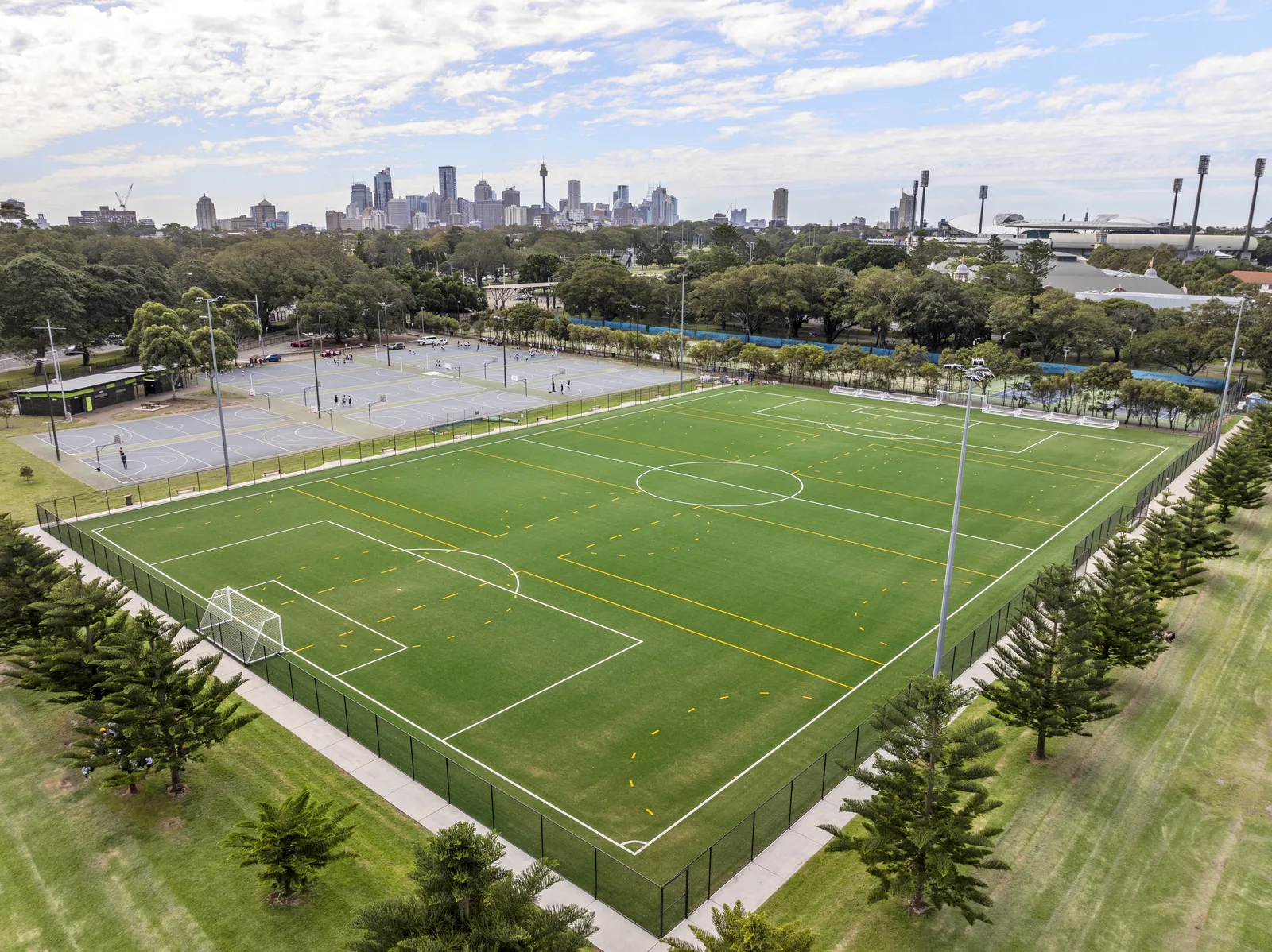 Synthetic sports pitch at Moore Park with Sydney skyline behind